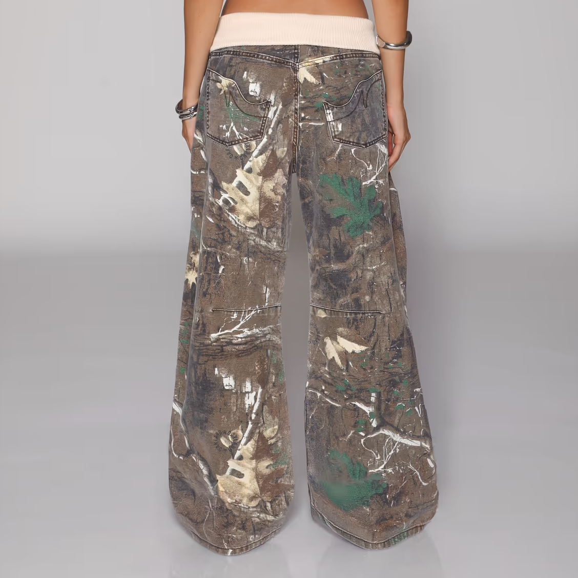 Camouflage pants worn by a person on a gray background