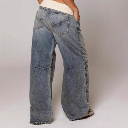 Person wearing wide-leg jeans on a plain background